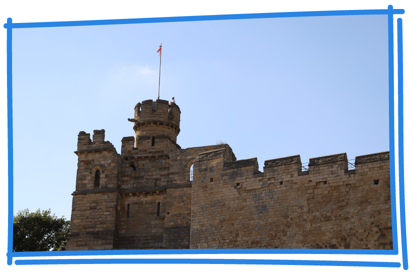 Lincoln castle walls with flag in sunlight